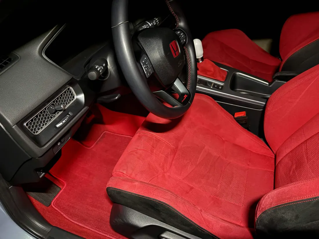 Red suede seats and floor mats in a detailed sports interior